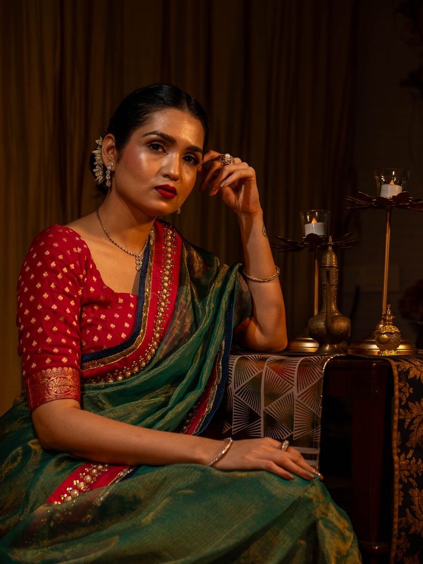 Model in a red and green saree wearing a diamond necklace