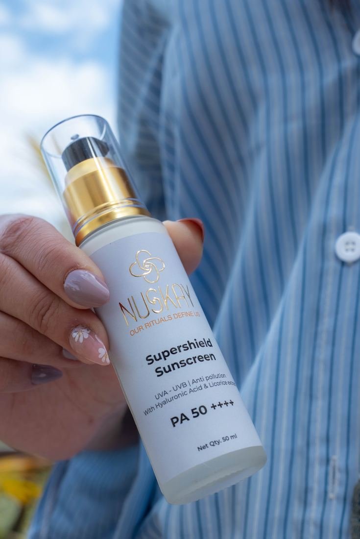 Hand holding a sunscreen bottle